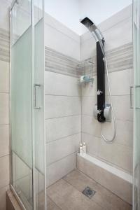 W łazience znajduje się prysznic ze szklanymi drzwiami. w obiekcie Διαμερίσματα στο Δυτικό Μοσχάτο w Pireusie