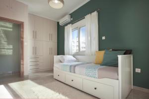 een slaapkamer met een wit bed en een raam bij Διαμερίσματα στο Δυτικό Μοσχάτο in Piraeus