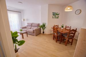 uma sala de estar com uma mesa e um sofá em VistAzul 402 em Lepe