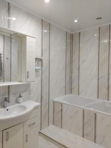 a white bathroom with a sink and a mirror at Видові 1к-2к апартаменти м Лівобережна in Kyiv