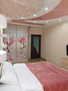 a bedroom with a white bed and a pink rug at Видові 1к-2к апартаменти м Лівобережна in Kyiv