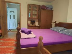 1 dormitorio con 1 cama con colchón morado en Vikendica krivaja Ribnica-Odmor na Krivaji, en Zavidovići