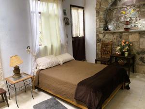 Un dormitorio con una cama y una pared de piedra. en Noria House in Exhacienda La Escalera, en Guanajuato 42 fotos más