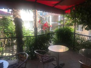 a patio with tables and chairs on a balcony at Oasis Guest House in Adler