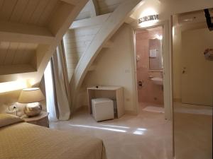 a bedroom with a staircase with a bed and a bathroom at Hotel Azzurra in Lido degli Estensi