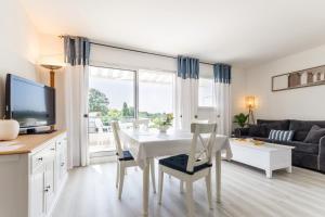 a kitchen and living room with a white table and chairs at La Terrasse du golf in Pornic