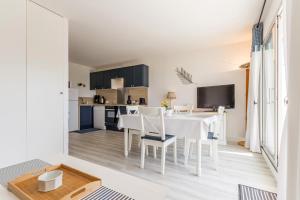 a kitchen and dining room with a white table and chairs at La Terrasse du golf in Pornic