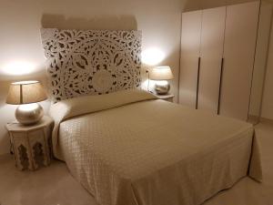 Hotel Azzurra في ليدو ديلي ايستينسي: غرفة نوم بسرير كبير ومصباحين