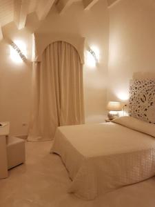 a white bedroom with a bed and a window at Hotel Azzurra in Lido degli Estensi