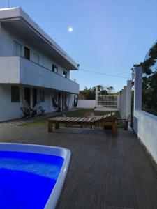 a house with a deck and a swimming pool at Casa da Gina in Santa Cruz Cabrália