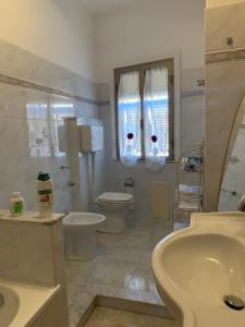 a bathroom with two toilets and a sink and a tub at Sea Life House in Alghero