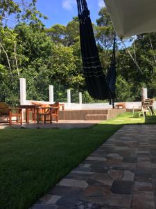 a patio with a table and a hammock in the grass at Casa da Gina in Santa Cruz Cabrália +14 photos