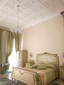 Palazzo Capece في Caivano: غرفة نوم بسرير وثريا