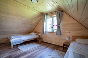 a room with two beds in a log cabin at Roztoczańska Ostoja in AdamÃ³w