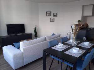 a living room with a couch and a table at Novia - Op de zeedijk, parkeren mogelijk in Ostend