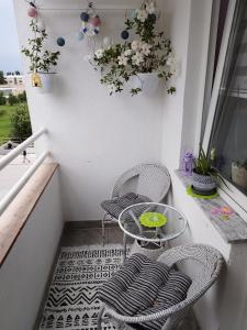 a balcony with two chairs and a table and a window at Apartman Dea in Sarajevo