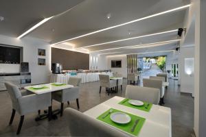 a dining room with white tables and chairs at Golden Sunset in Boukari