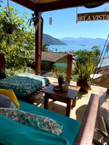 a patio with a hammock and a view of the ocean at Pousada Bela Vista in Abraão