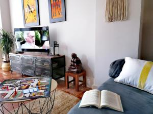 sala de estar con cama y TV en El Sumiciu, en Avilés