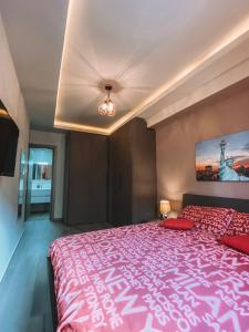 1 dormitorio con 1 cama grande con colcha rosa en LOVELY MODERN APARTMENT IN ST.JULIAN, en San Julián
