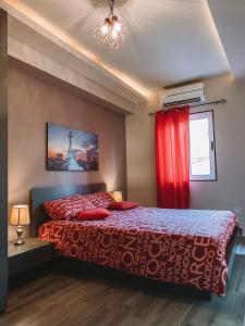 1 dormitorio con cama y cortina roja en LOVELY MODERN APARTMENT IN ST.JULIAN, en San Julián