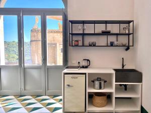 een keuken met een wit aanrecht en een wastafel bij Super Giù - Monolocale Superior in Ragusa +20 foto's