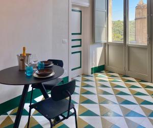 een eetkamer met een tafel en stoelen en een geometrische vloer bij Super Giù - Monolocale Superior in Ragusa