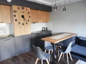 Apartament Shadow في بياويستوك: مطبخ مع طاوله وبعض الكراسي وكاونتر