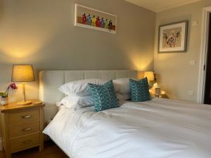 a bedroom with a white bed with blue pillows at No 12 Furze Croft in St Ives