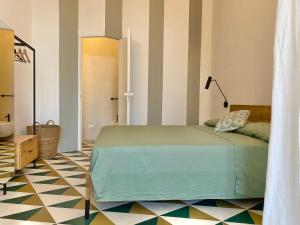 een slaapkamer met een groen bed en een vloer bij Super Giù - Monolocale Superior in Ragusa