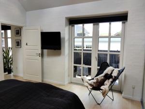 a bedroom with a chair with a dog in it at Værelser i midtbyen - 117 m2 apartment in Herning