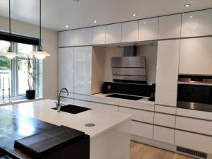 eine große Küche mit weißen Schränken und einem Waschbecken in der Unterkunft Værelser i midtbyen - 117 m2 apartment in Herning