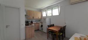 uma cozinha com uma mesa e cadeiras e um frigorífico em El Colmenar Apartamento em Madrid