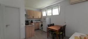 a kitchen with a table and chairs and a refrigerator at El Colmenar Apartamento in Madrid