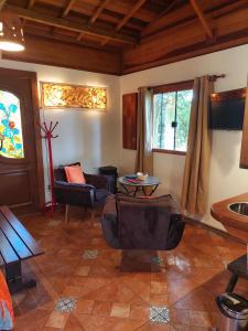 a living room with chairs and a table at Pousada Anecuém in Monte Verde