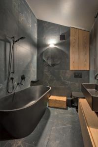a bathroom with a large tub and a sink at Modern studio in bohemian Uzupis, Vilnius in Vilnius