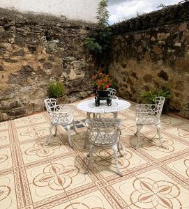 een patio met een tafel en 4 stoelen op een tegelvloer bij La Capelina Apartment in ExHacienda la Escalera in Guanajuato