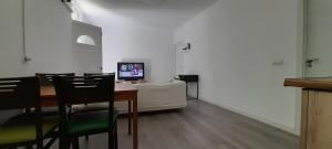 Habitación con mesa con sillas y TV. en El Colmenar Apartamento, en Madrid