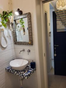 La salle de bains est pourvue d'un lavabo et d'un miroir. dans l'établissement Appartamenti Bellavista 107, à Chioggia