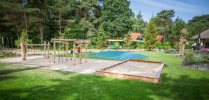 een speeltuin in een tuin met een zwembad bij Boszicht in Diever