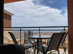 eine Terrasse mit einem Tisch und Stühlen auf dem Balkon in der Unterkunft Vivienda adosada en Castillo, Caleta de Fuste in Caleta de Fuste