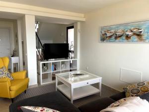 ein Wohnzimmer mit einem Sofa und einem TV in der Unterkunft Vivienda adosada en Castillo, Caleta de Fuste in Caleta de Fuste