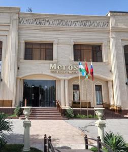 a métis building with two flags in front of it at Meros Boutique Hotel in Samarkand