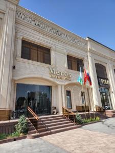 a métis building with flags in front of it at Meros Boutique Hotel in Samarkand