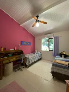 - une chambre avec un ventilateur de plafond et un bureau dans l'établissement Casa Aconchego - Arraial D Ajuda- Bahia, à Arraial d'Ajuda