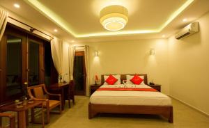 a bedroom with a bed with red pillows on it at Village Moon Villa in Hoi An