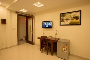 a room with a desk and a television on the wall at Village Moon Villa in Hoi An