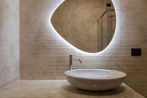 a bathroom with a white sink and a mirror at DESTASU' Bed and Wellness in Castel del Monte