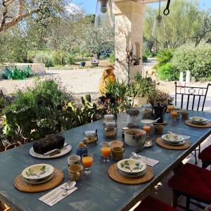 une table bleue avec des assiettes et des verres de jus d'orange dans l'établissement Casa della Scrittrice, à Ostuni