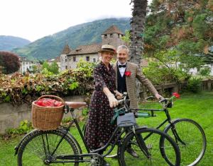 Un uomo e una donna in piedi accanto a una bicicletta di Bed&Bike Bruneck - Brunico a Brunico